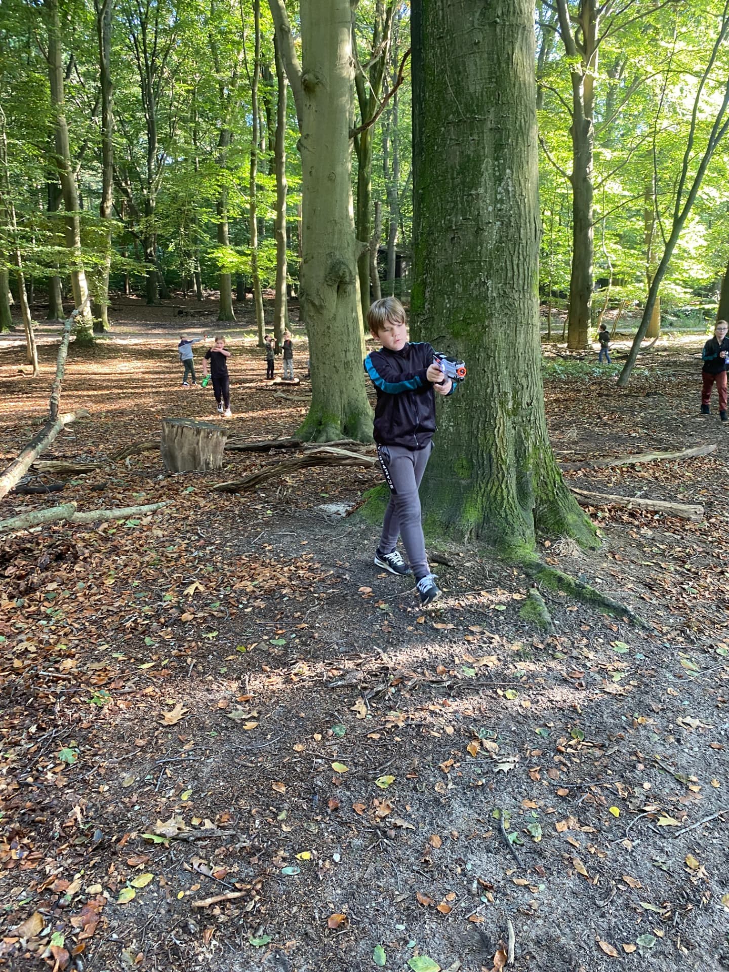 Jongen aan het lasergamen tussen de bomen – verhuur door Uitjes2go in Ede