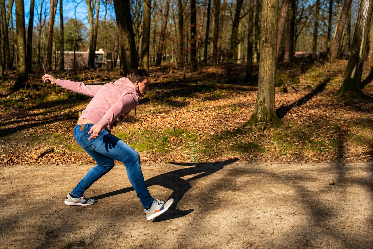 Een kloot werpen op een bospad tijdens klootschieten – verhuur door Uitjes2go in Ede